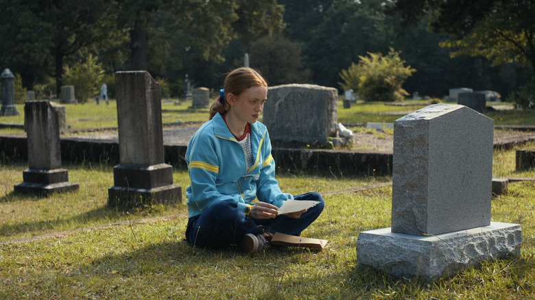 Max Mayfield sitting in front of Billy's grave