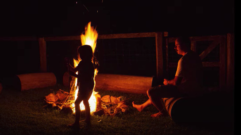 Boy standing by fire