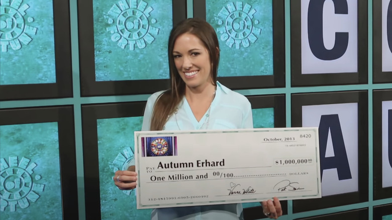 Autumn Erhard holding a million dollar check on the Wheel of Fortune set