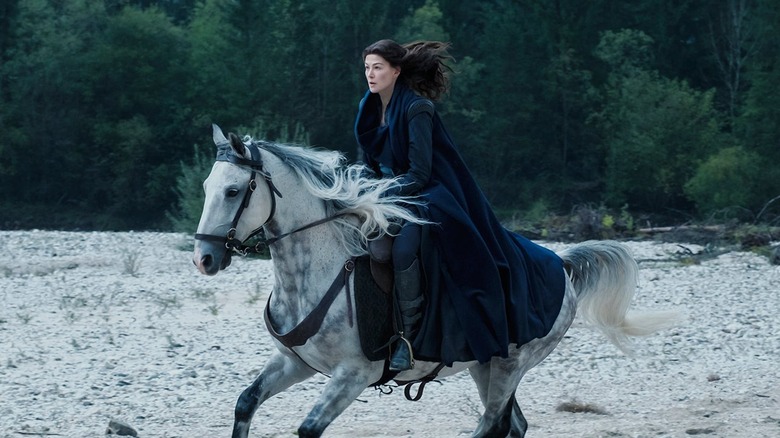 Rosamund Pike rides a horse as Moiraine