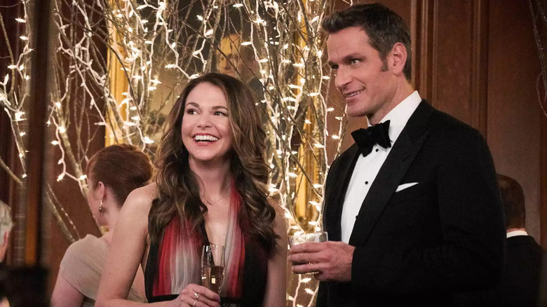 Liza and Charles standing and talking pleasantly at a party in "Younger"