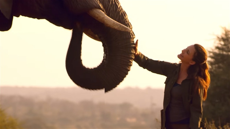 Kate petting an elephant in Holiday in the Wild (2019)