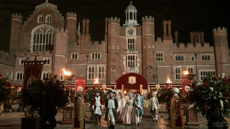 A group of royals in front of a castle