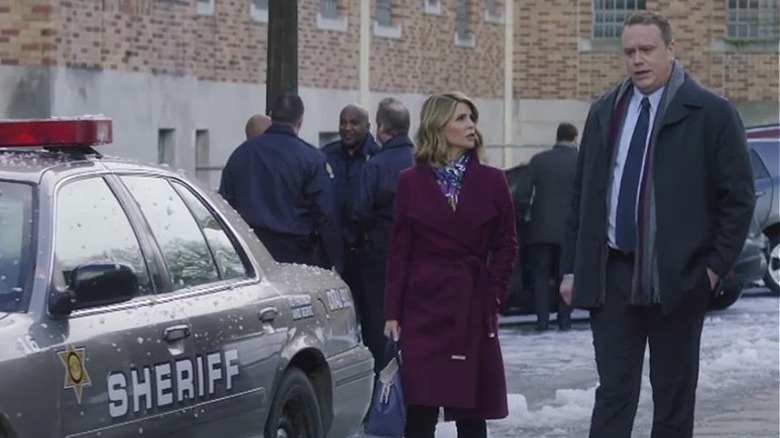 Jennifer walks with witness by cop car