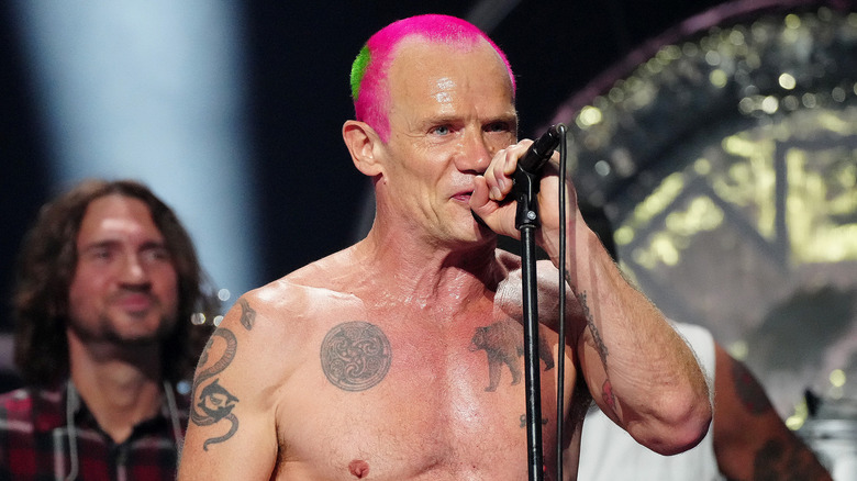 Shirtless Flea with a microphone