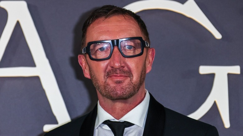 Ralph Ineson in glasses and a suit