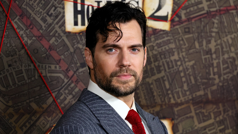 Henry Cavill wearing red tie at premiere