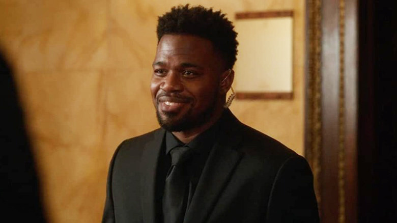 Daniel Washington smiling in a suit in The Sleepover