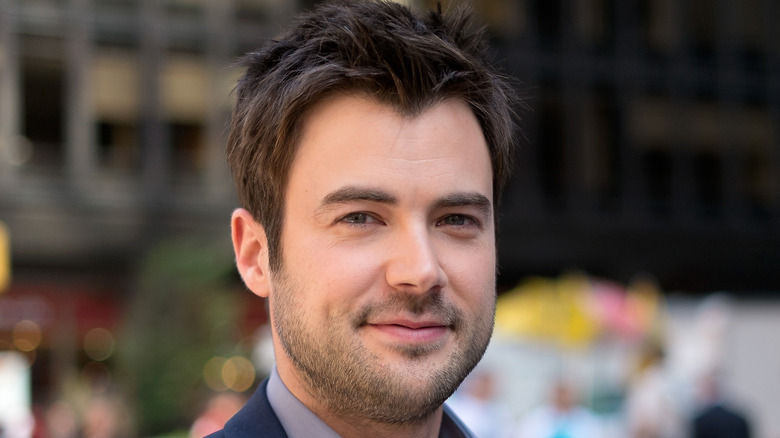 Matt Long poses and smiles in a cityscape setting