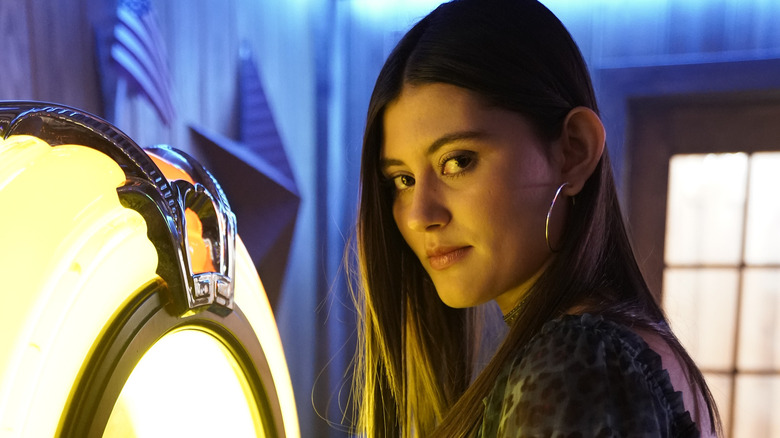 Emma Milani stands at a jukebox in "Monarch"