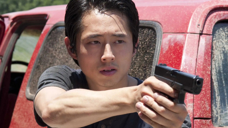 Man holding a gun next to a truck