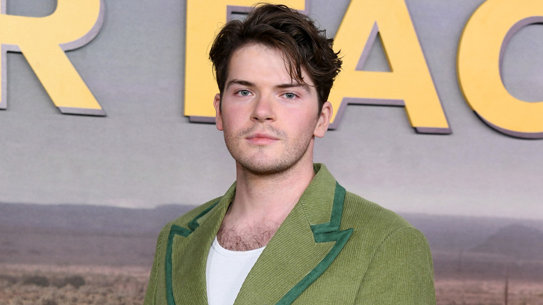 Colton Ryan wearing green blazer