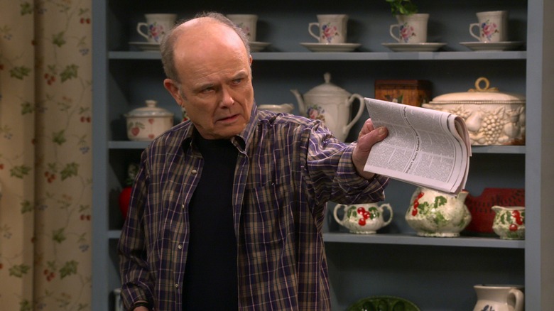 Red Forman pointing with paper