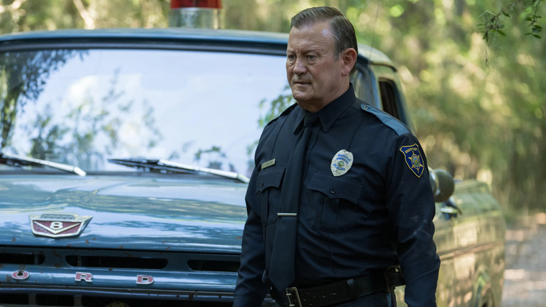 Sheriff Ed Jackson stands in front of a pickup truck