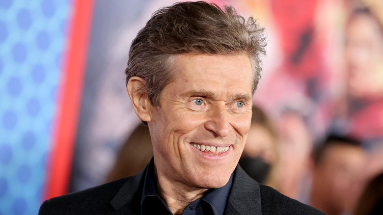 Willem Dafoe, grinning