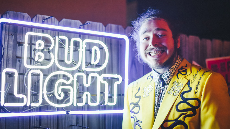 Post Malone posing Bud Light sign