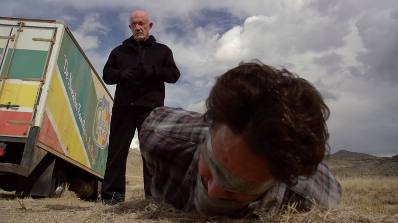 Mike Ehrmantraut standing over blindfolded, tied-up man