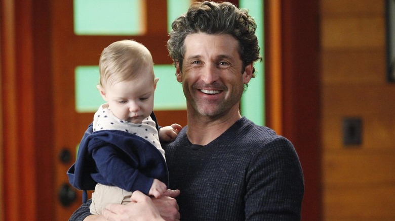 Derek holding baby Bailey and smiling on Grey's Anatomy