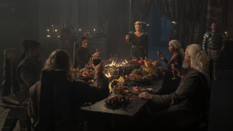 Rhaenyra raising a glass at a table of dragonriders on House of the Dragon