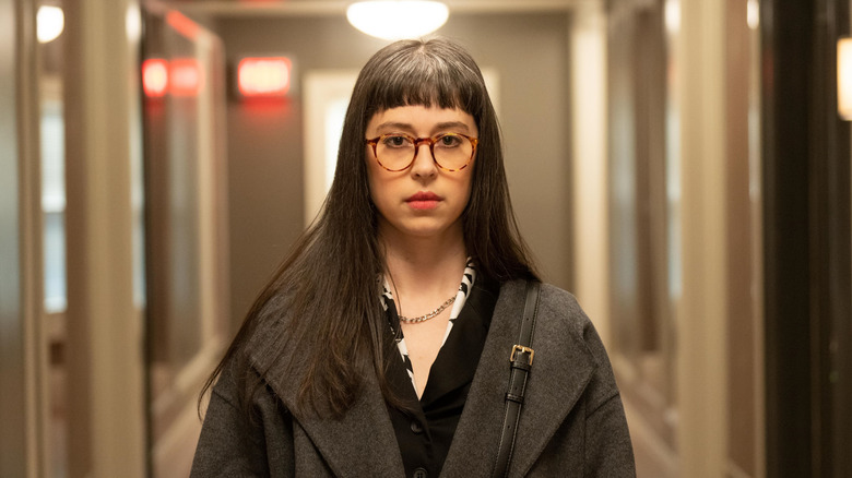 Poppy White walking down the hall with a blank expression