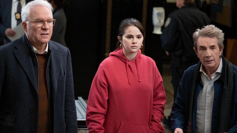 Charles, Mabel, and Oliver looking nervous in jail lobby