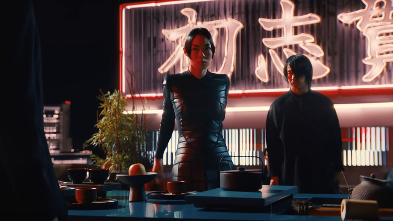 Akira stands next to an assassin in front of John Wick