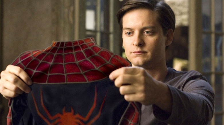 Peter Parker holding Spider-Man suit