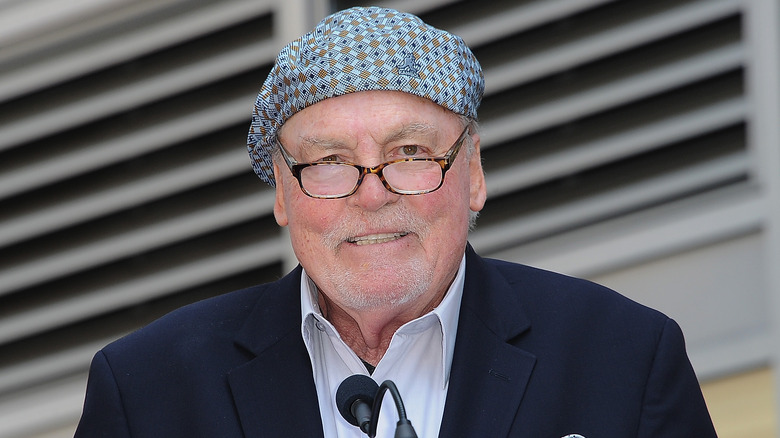 Stacey Keach wearing glasses and blue patterned hat