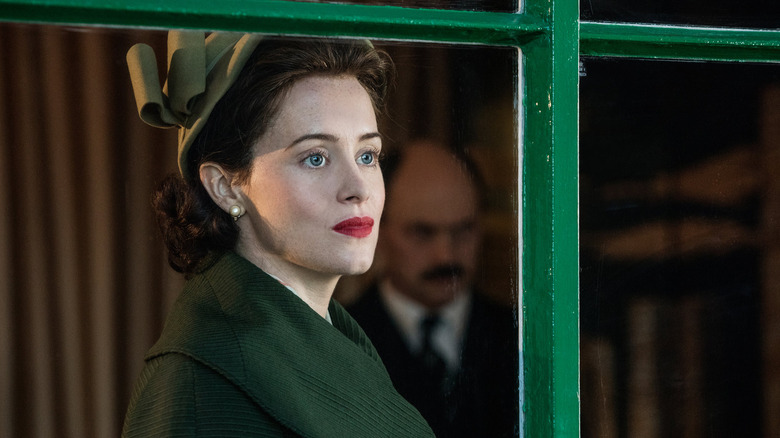 Claire Foy as Queen Elizabeth II looking out the window on The Crown