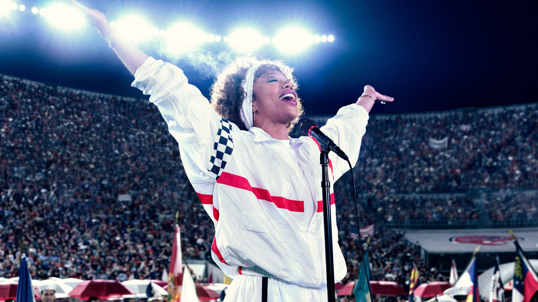 Whitney Houston singing in stadium with arms up