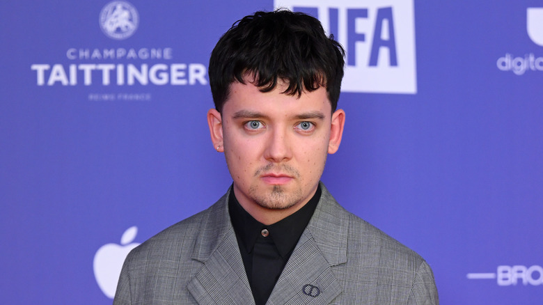 Asa Butterfield looking ahead grey jacket