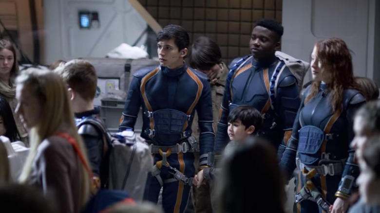 Gordon Cormier with adults and other children in Lost in Space's final episode