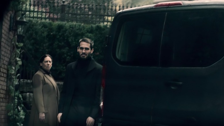 Burke and Aunt Lydia standing next to a van