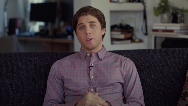 Lukas Gage sitting on couch