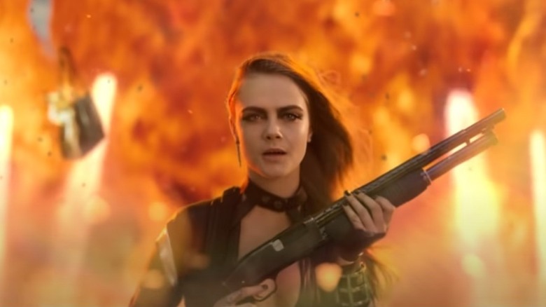 Cara Delevingne cocking a shotgun