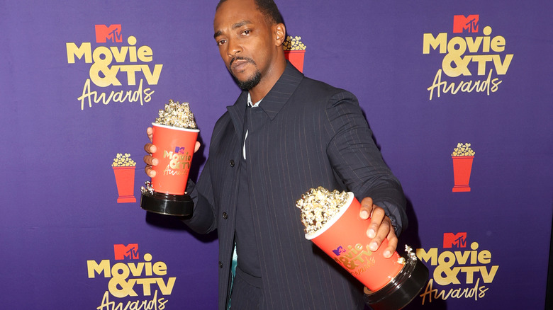 Anthony Mackie holding two awards