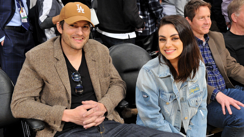 Ashton Kutcher and Mila Kunis at a basketball game