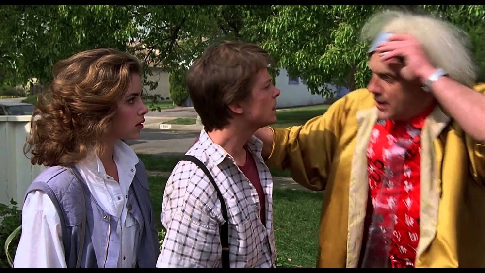 Michael J. Fox as Marty McFly, Christopher Lloyd as Doc Brown, and Claudia Wells as Jennifer Parker in Back to the Future