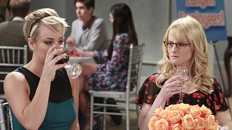 Bernadette angrily watching Penny drink wine