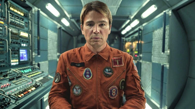 David wearing an orange jacket covered in patches