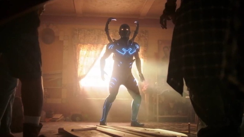 Blue Beetle busting open the living room