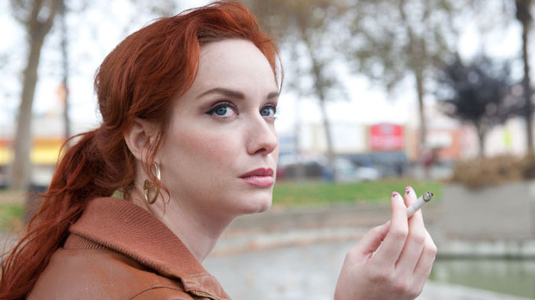 Christina Hendricks sitting in a park smoking