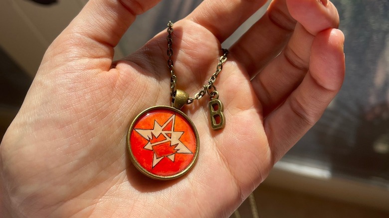 Brie Larson holding Captain Marvel pendant