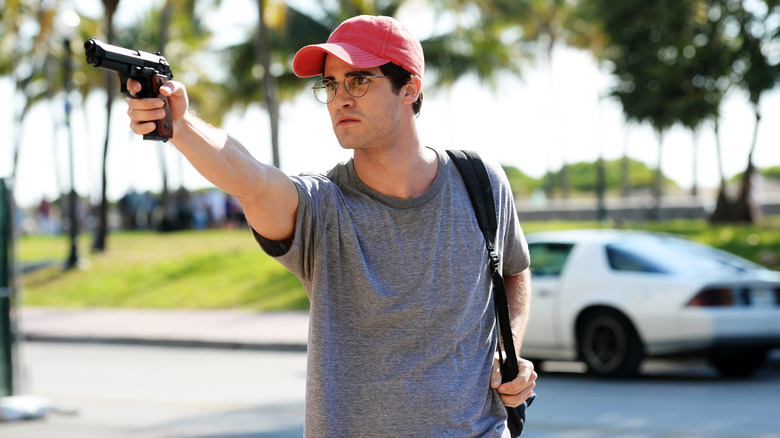 Darren Criss pointing a gun