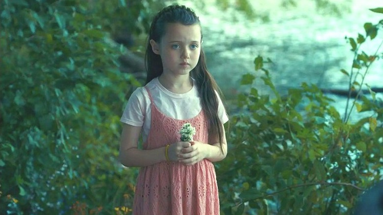 Violet holding flowers in the woods