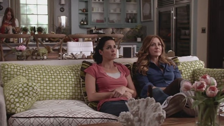 Angie Harmon and Sasha Alexander sitting on couch