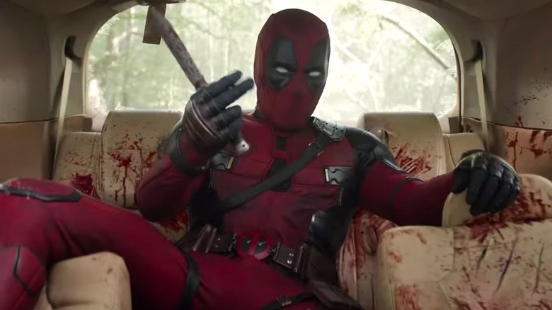 Deadpool sitting in the back of a bloody car