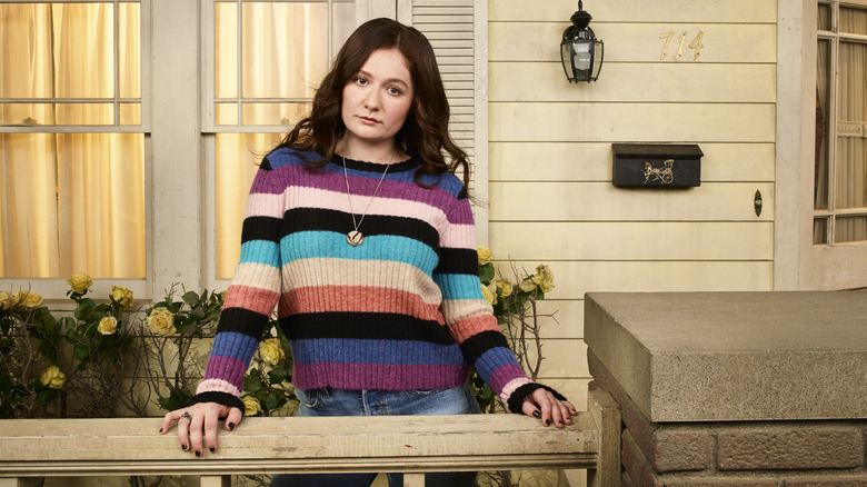 Emma Kenney poses on a porch