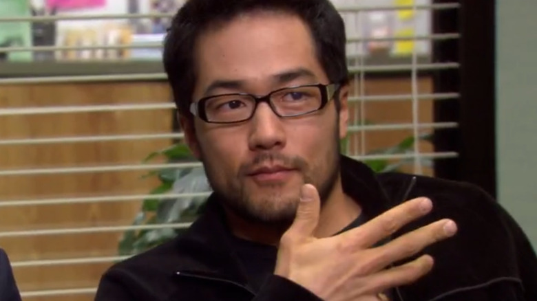 Koh from The Office holding up his hand