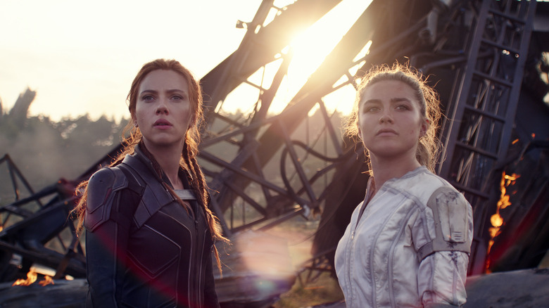 Scarlett Johansson and Florence Pugh standing in front of wreckage